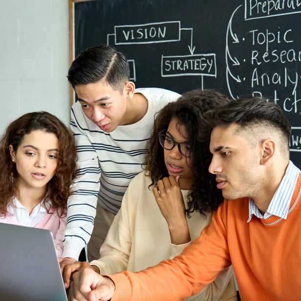 Students of different races looking at laptop
